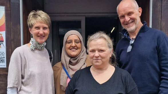 Four members of the EYAI community smiling together at the hall entrance